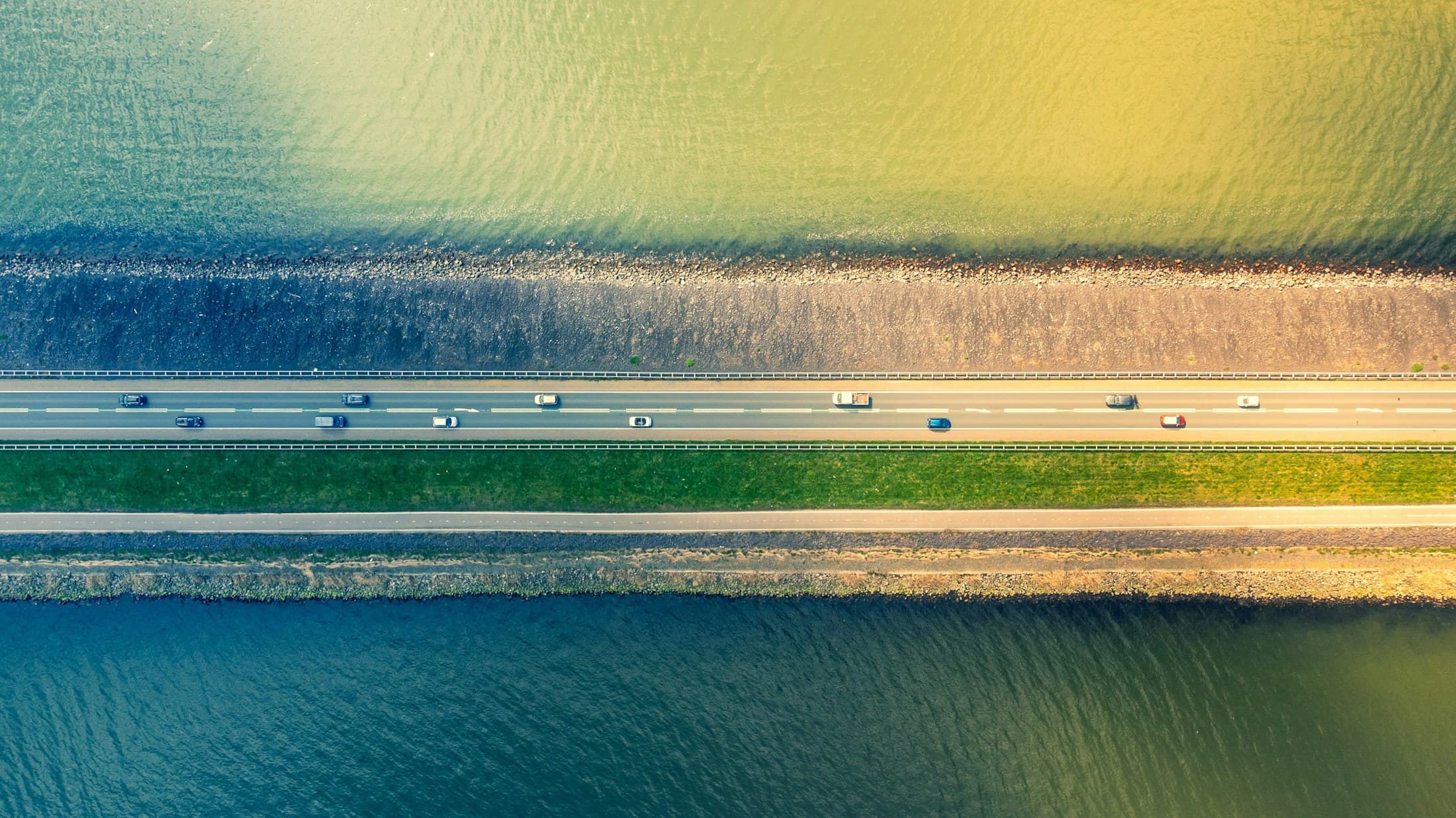 Luchtbeeld van de Houtribdijk: water aan beide kanten, de weg op de dijk